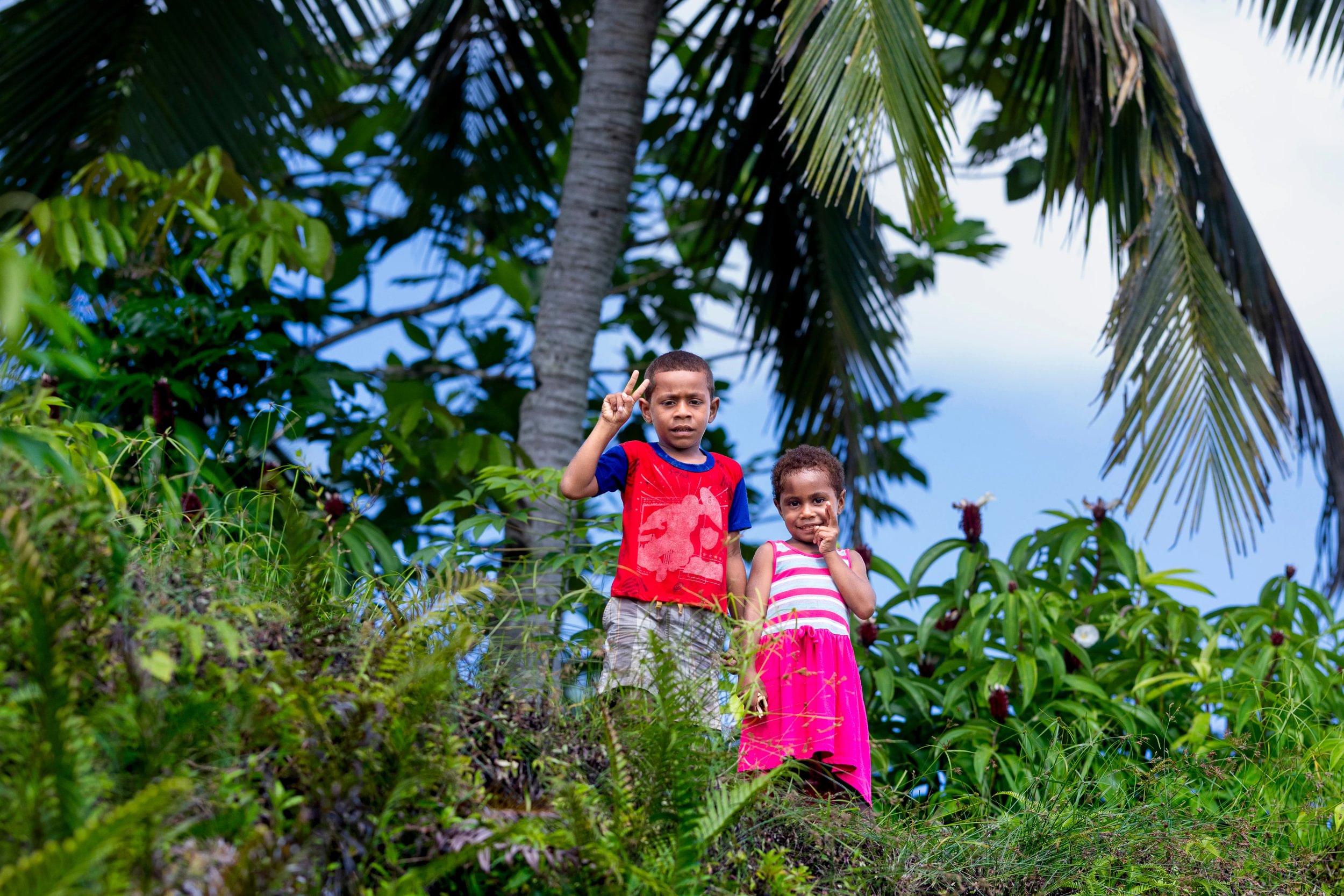 Two kids make peace sign in village - Large